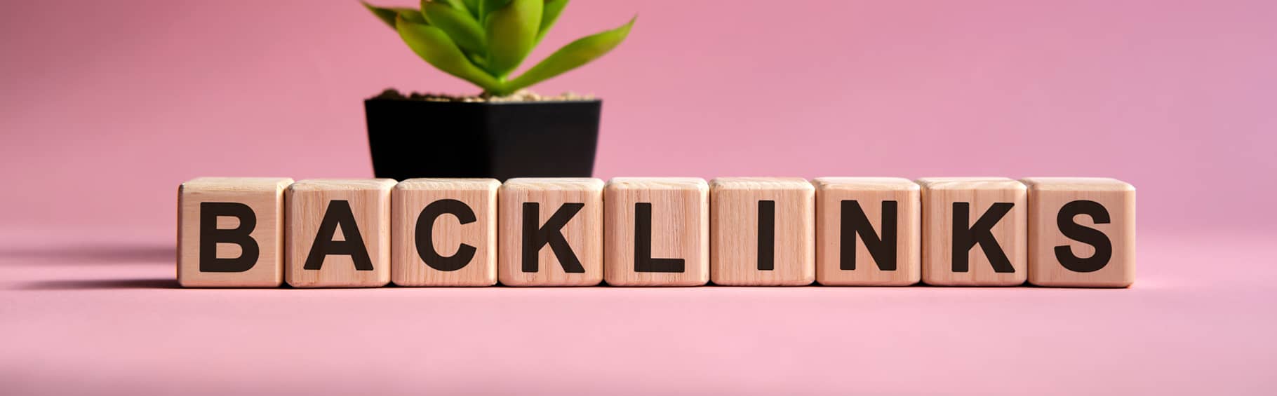 The words 'backlinks' spell out with cubes in front of a pink backdrop.